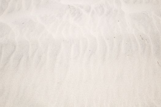 A peaceful close-up of white sand dunes showcasing natural textures and patterns, perfect for backgrounds.