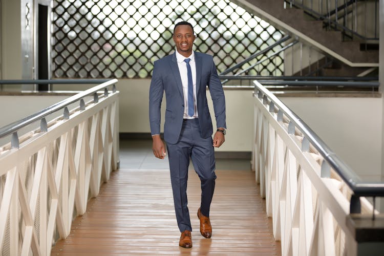 Photo Of A Man In A Suit Smiling While Walking