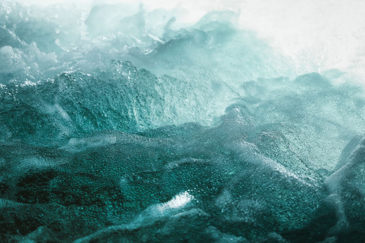 vivid and textured image of turquoise ocean waves crashing with foamy