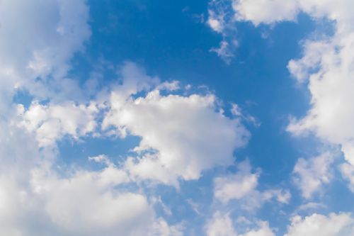 Free A tranquil blue sky filled with soft, fluffy white clouds, perfect for peaceful backgrounds. Stock Photo