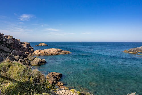 A Rocky Shore Near the Sea Under the Blue Sky