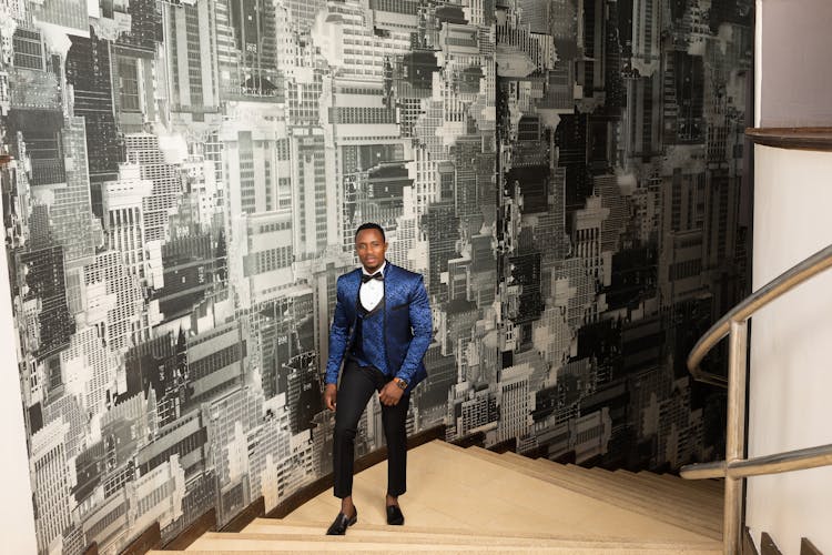 Man In Blue Suit Walking Up The Staircase
