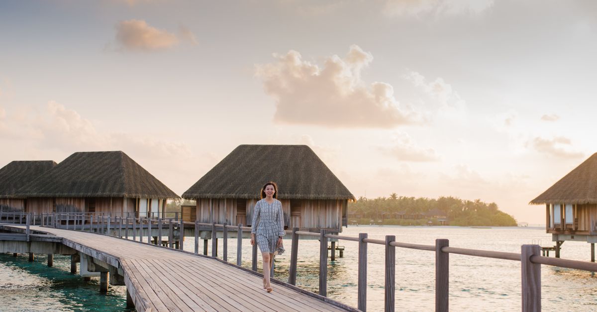 Viajera con eSIM para la Polinesia Francesa frente a los bungalows sobre el agua de Bora Bora