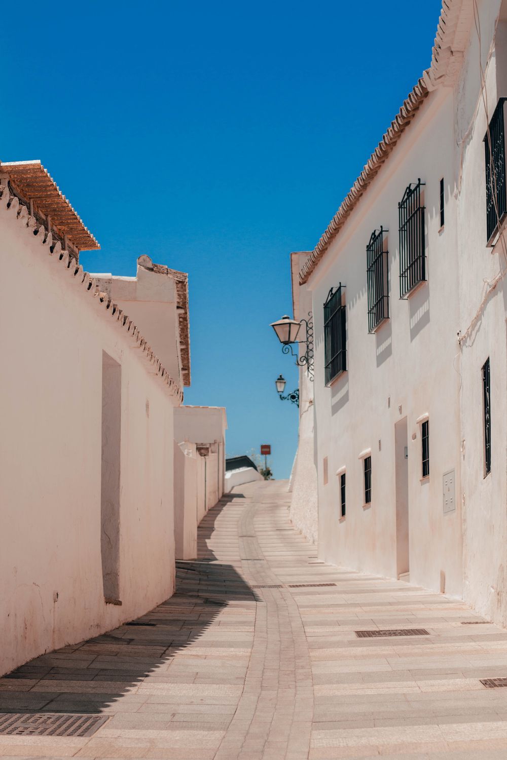 Calle empedrada con casas blancas en Mijas, Málaga