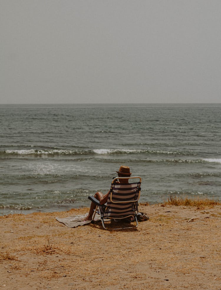 Man Relaxing In A Deckchair On A Beach