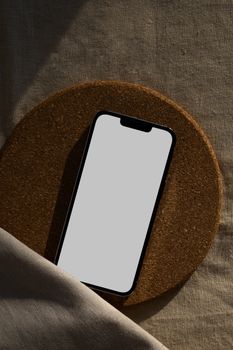 Smartphone with blank screen placed on textured surface, ideal for mockup designs.