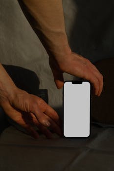 Close-up of hands holding a smartphone with a blank screen, perfect for app or website mockup.