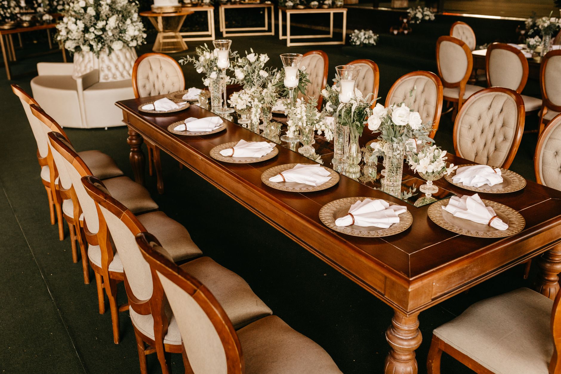 Beautifully decorated dining table set for a formal event with floral arrangements and fine tableware.