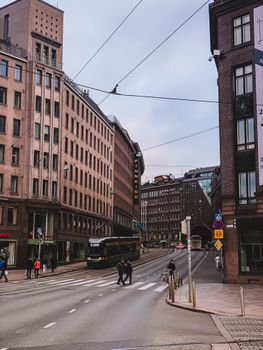 Street view of Helsinki showcasing tram, pedestrians, and urban architecture.