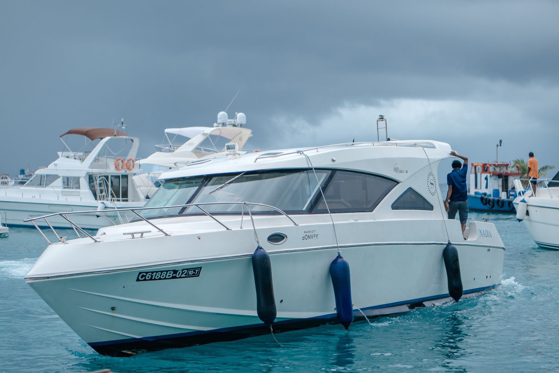 Modern luxury yacht navigating through calm ocean waters on an overcast day.