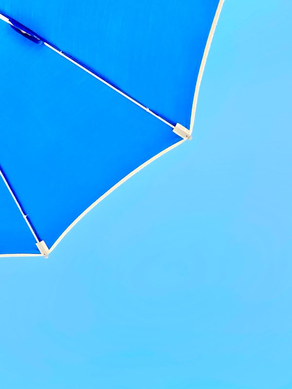 An open umbrella against a clear blue sky