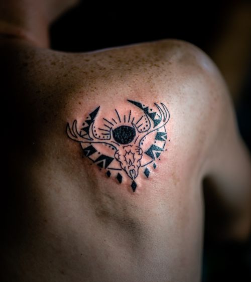 Free Close-up of a black ink tattoo depicting a geometric deer design on a person's shoulder. Stock Photo