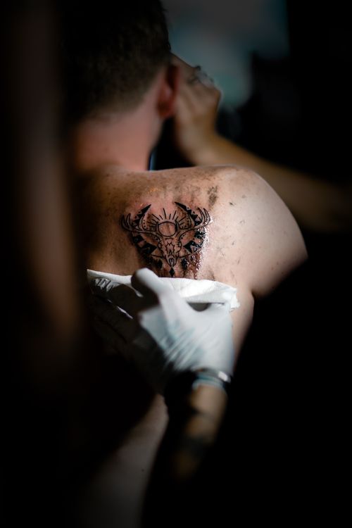 Free A skilled tattoo artist working on a detailed shoulder tattoo design. Passionate artistry on skin. Stock Photo