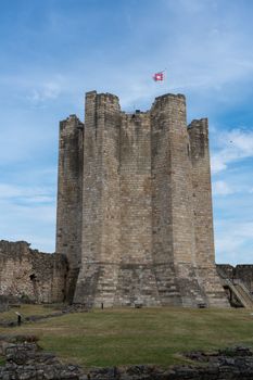 A historic landmark, Conisbrough Castle stands tall under a blue sky in South Yorkshire, England.