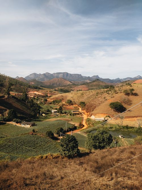 Free A peaceful valley with fields and mountains under a bright sky. Stock Photo