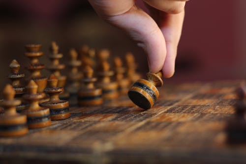 A Person Holding Wooden Chess Piece