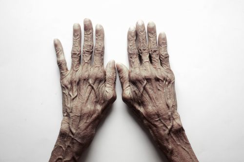 Free Top view of senior adult's hands on a white background, showcasing age and texture. Stock Photo