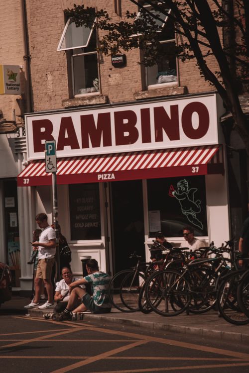 Free A busy Dublin street featuring bicycles and a pizzeria on a warm day. Stock Photo