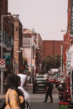 Lively city street filled with pedestrians and cars, capturing the essence of urban life.