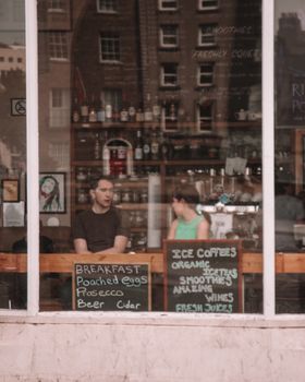 Charming urban café setting with two people inside, capturing a relaxed atmosphere.