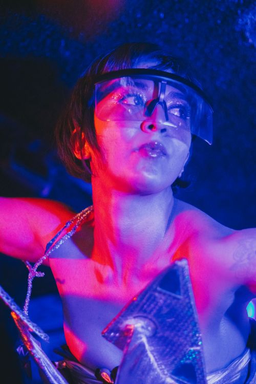 Free Vibrant futuristic portrait of a woman in neon lighting and creative attire. Stock Photo