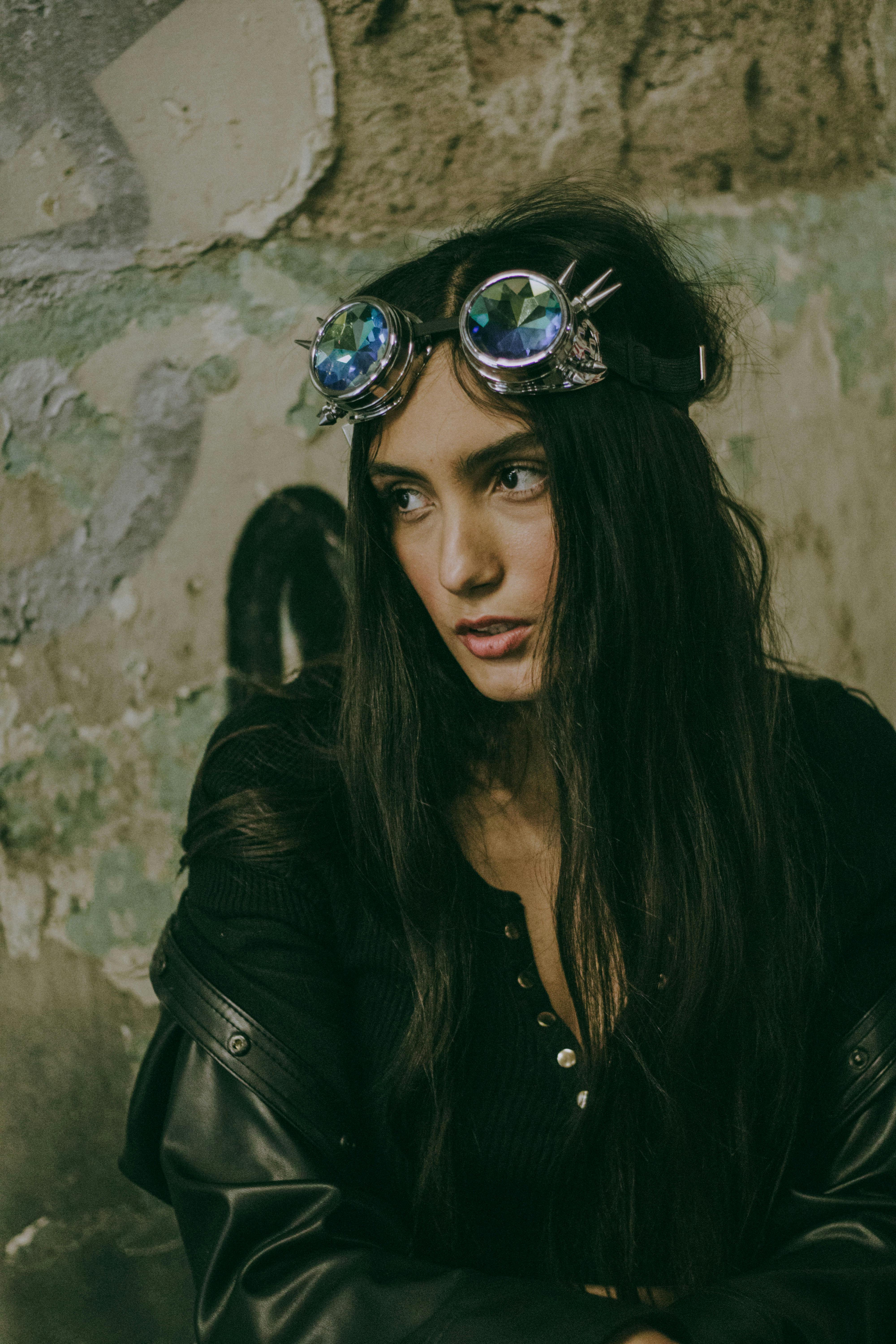 Portrait of a woman in steampunk fashion with retro-futuristic goggles against an urban backdrop.