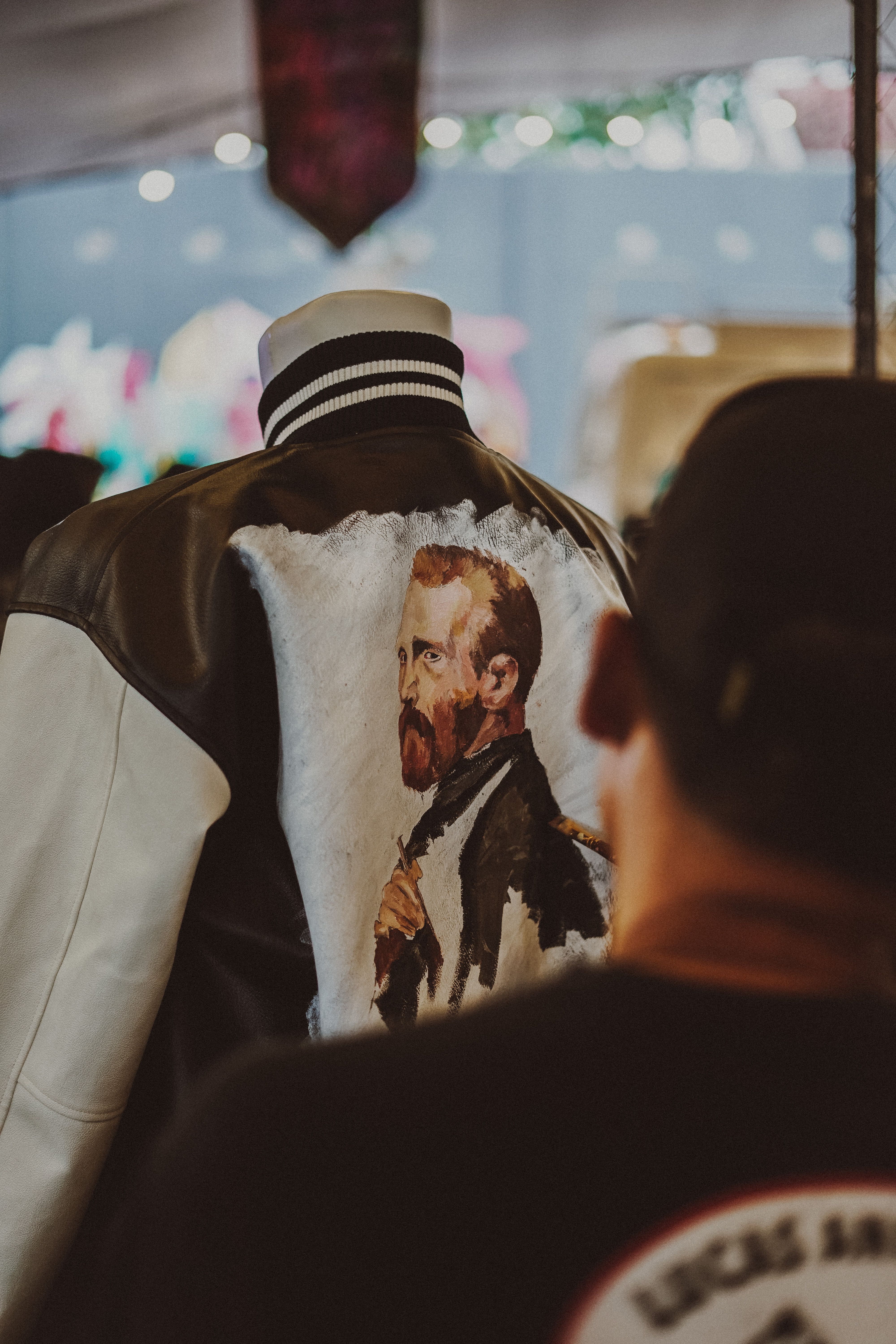 Artistic jacket featuring Van Gogh painting displayed on a mannequin at an event.
