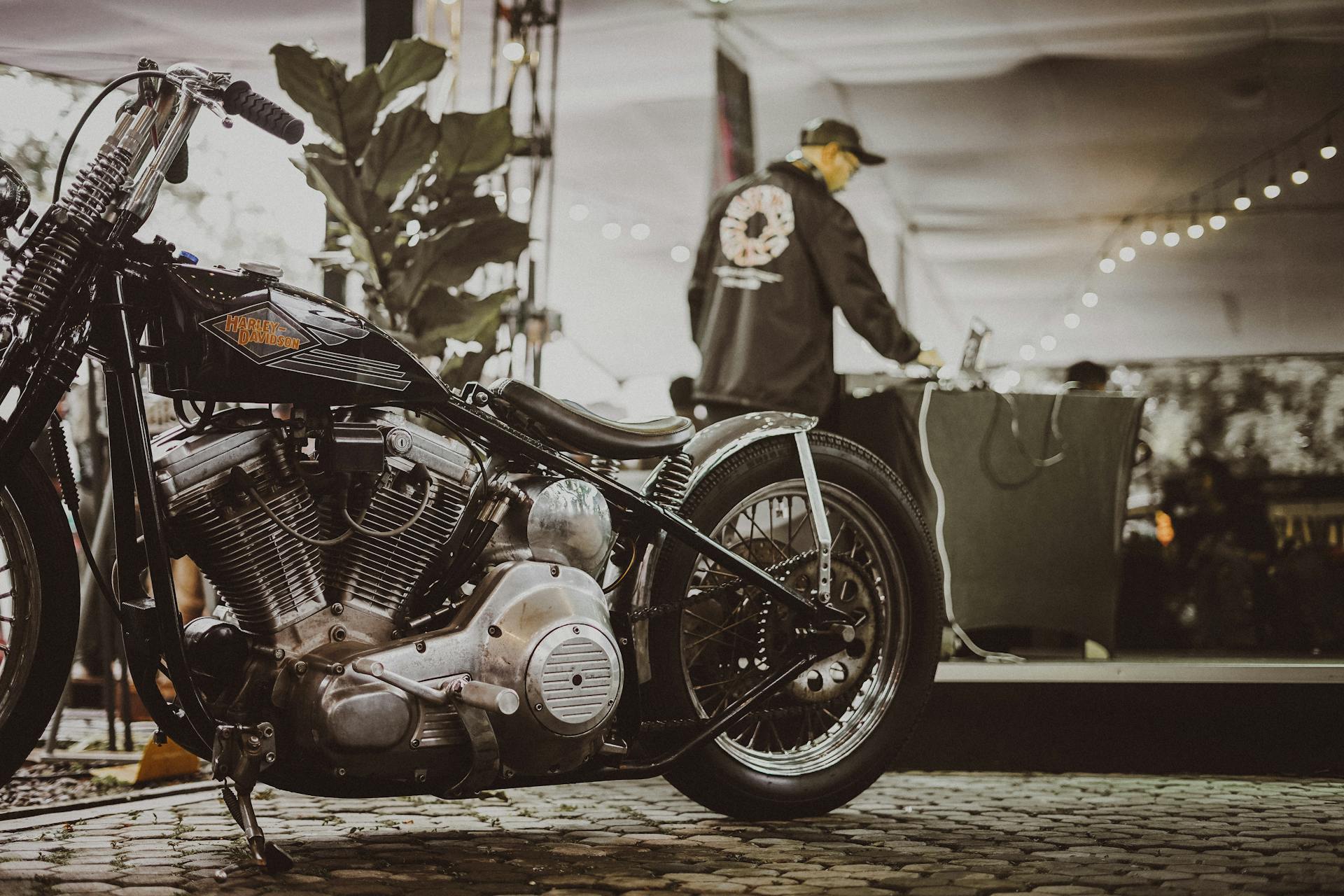 Stylish Harley Davidson motorcycle parked at an indoor event with a DJ nearby.