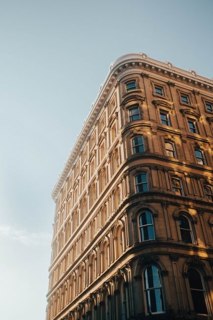 Low angle view of a historic building with arches in Montreal's urban landscape.
