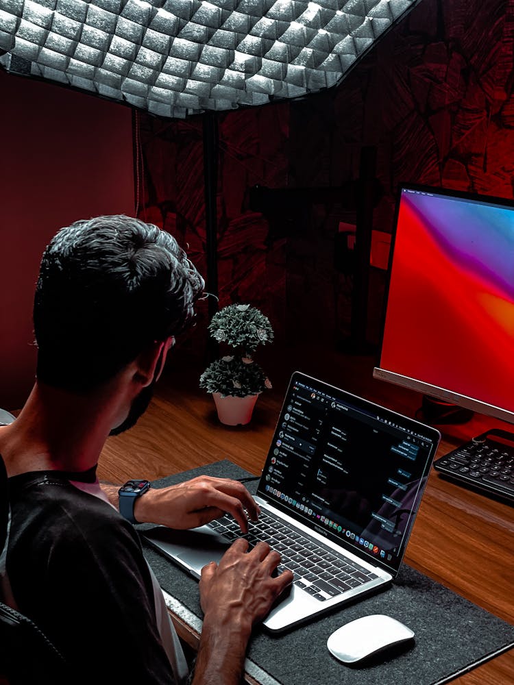 Man Using Laptop On Wooden Table