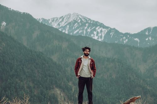 Free A man stands confidently in Baramulla's scenic mountains, embracing adventure and solitude. Stock Photo