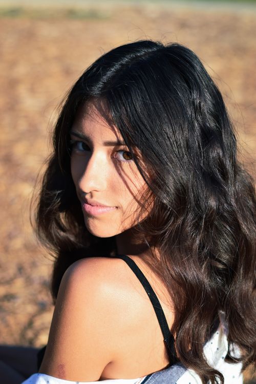 Free Close-up of a young woman enjoying a sunny day outside, highlighting natural beauty. Stock Photo