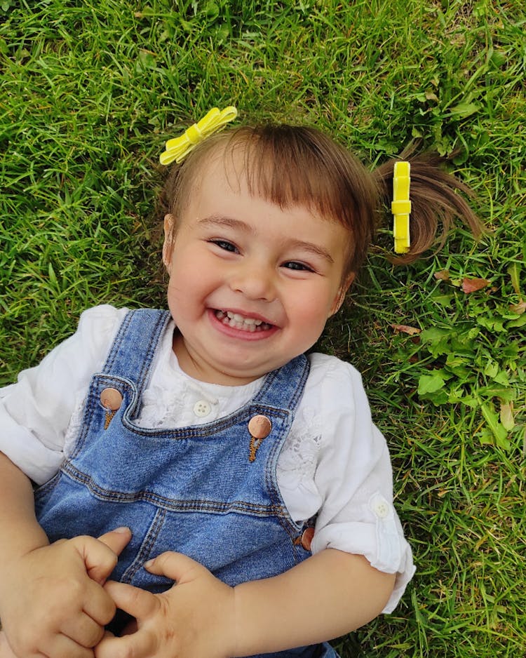 Cute Little Girl Lying On Grass