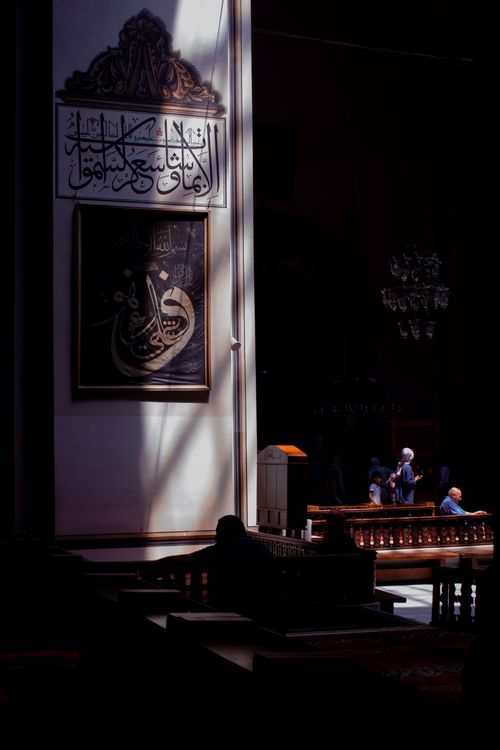 Free Captivating interior of a traditional mosque in Bursa with Arabic script and shadows. Stock Photo