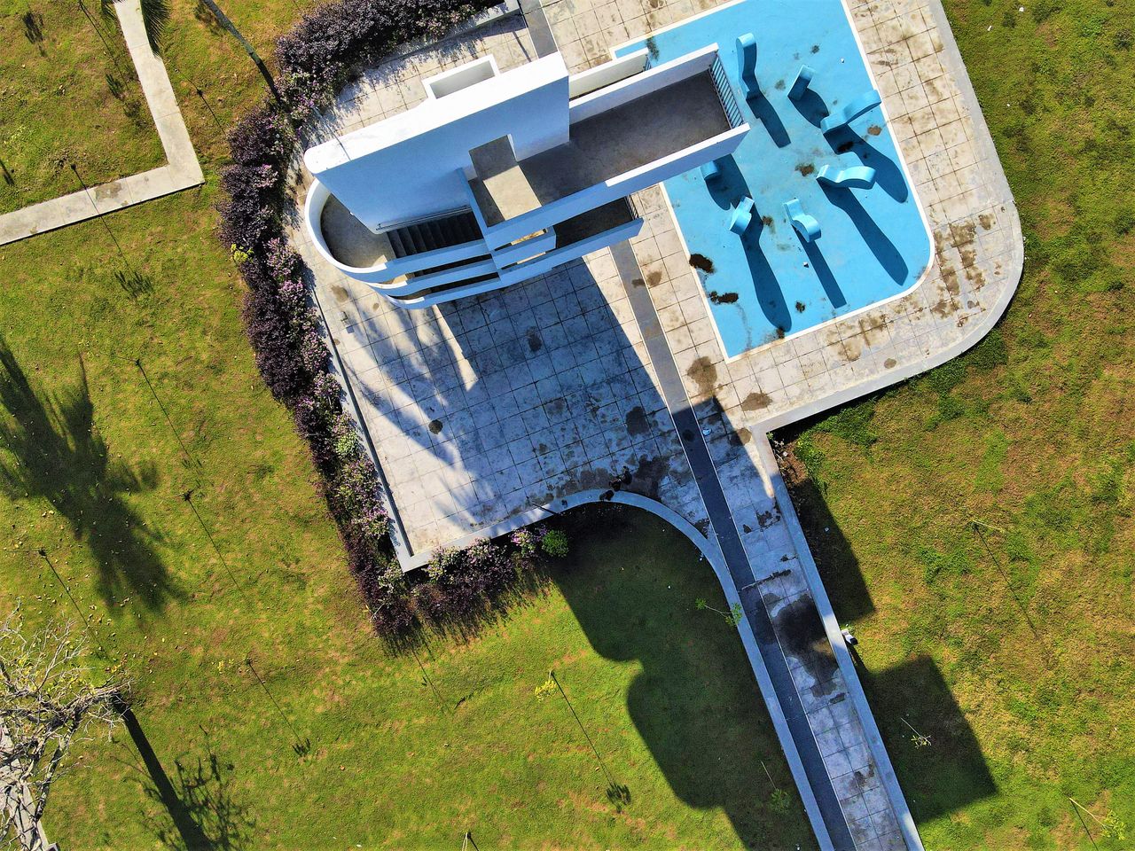 aerial view of a modern architectural structure casting shadows on a s