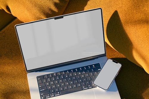 Free Laptop and a Smartphone on Top of a Sofa Stock Photo