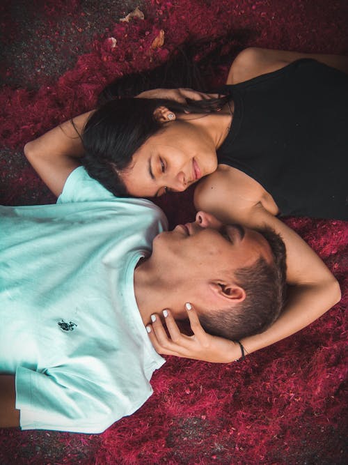 Free Couple Lying on Ground While Holding Their Hands Stock Photo