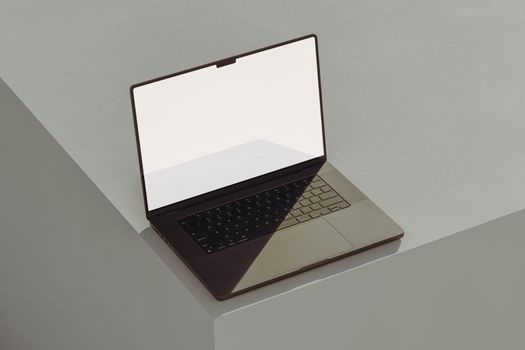 A sleek modern laptop with a blank screen on a minimalist gray surface. Perfect for tech presentations.