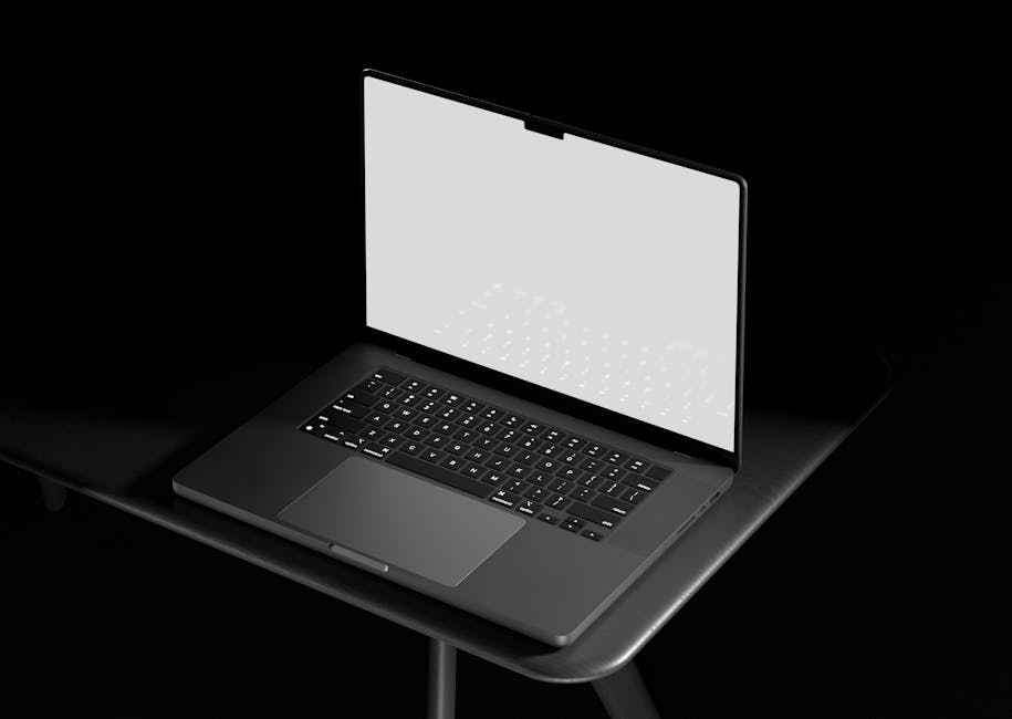 Does a Secured Card Build Credit From Scratch? Open laptop with a blank white screen on a table in a dark setting, suitable for mockups and designs.