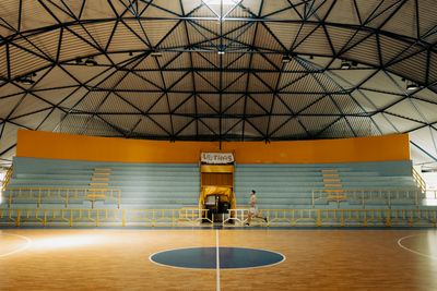 Empty indoor basketball hall — photo by Matteo Basile on Pexels
