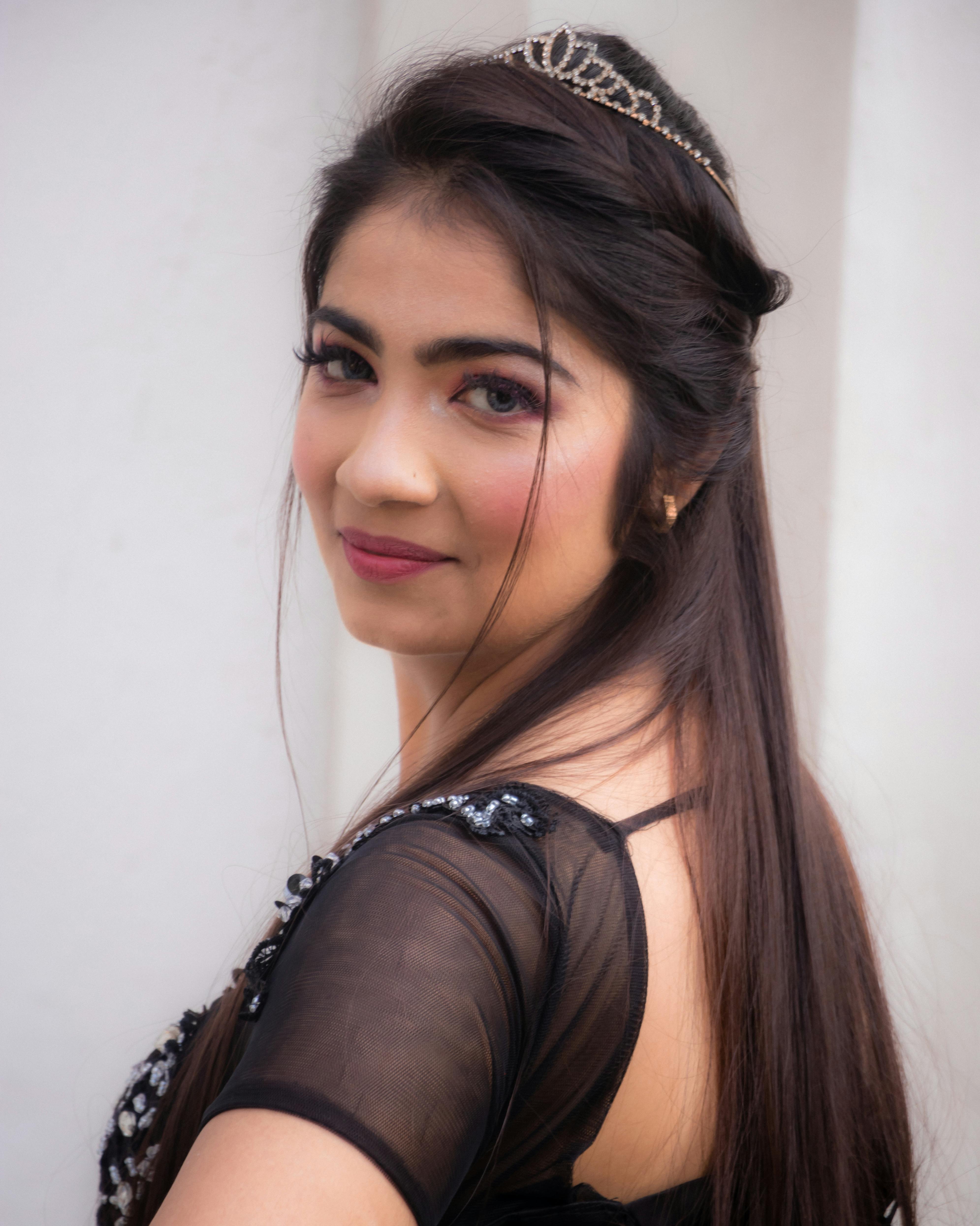 Charming portrait of a woman with long hair and tiara, embodying elegance and beauty.