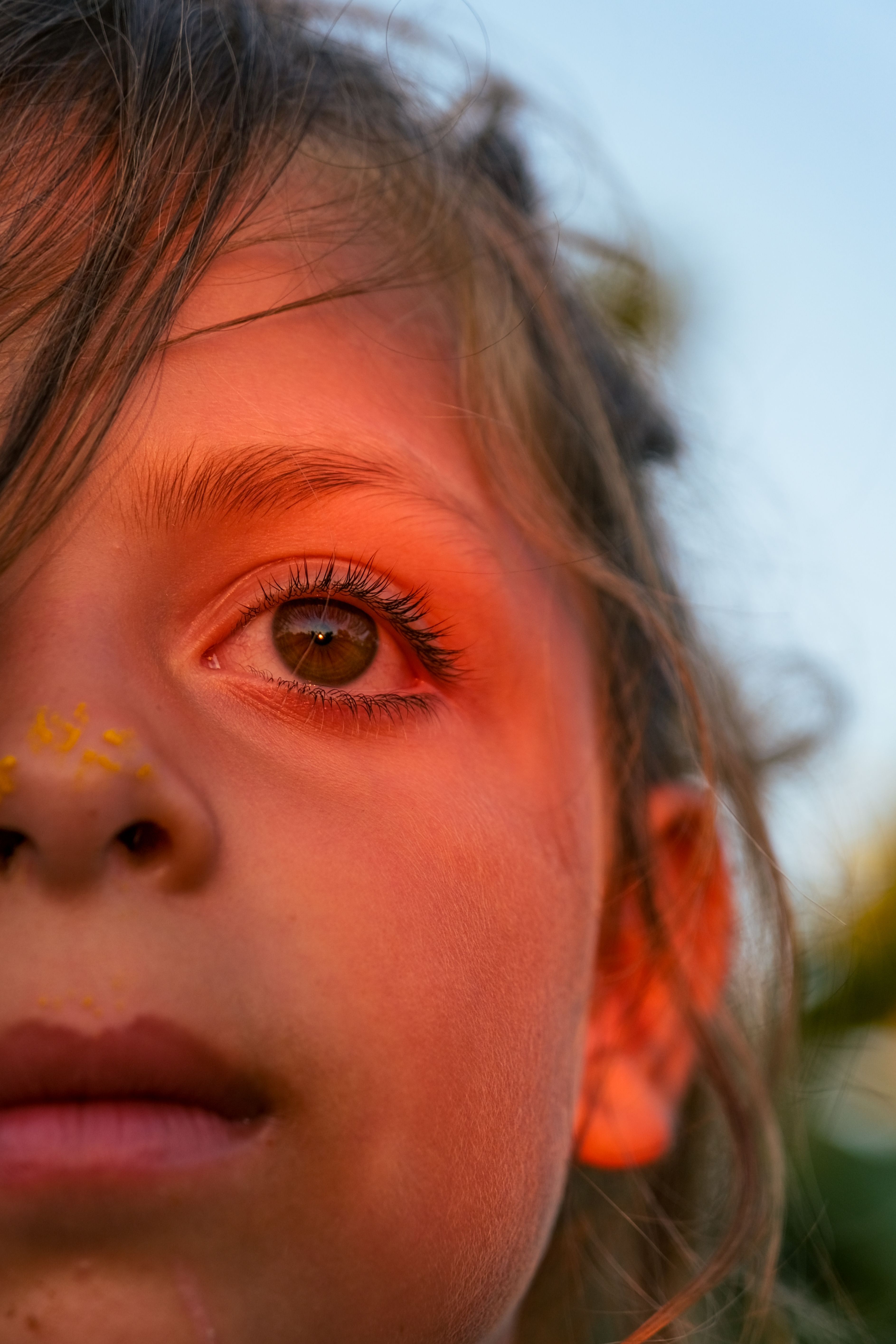 Captivating close-up of a child's face illuminated by warm sunset light.