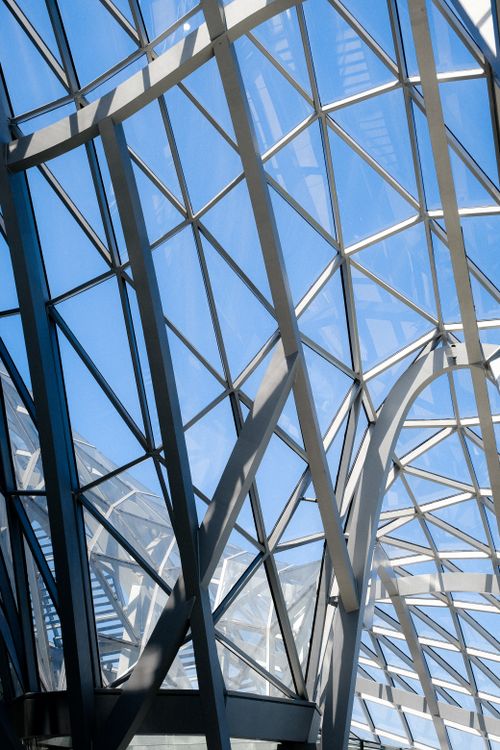 Free Contemporary architectural design showcasing glass and metal structures with natural light. Stock Photo