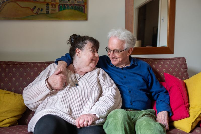 Happily married couple embracing on a sofa at home