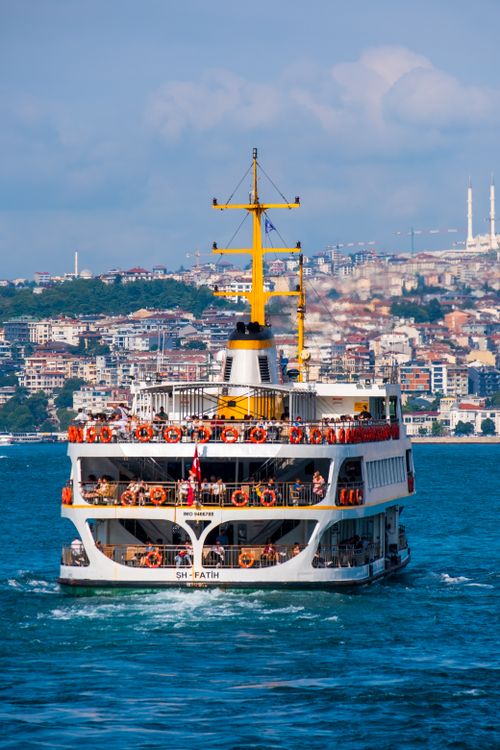 Free A ferry sailing on the Bosphorus with people on board, showcasing Istanbul's skyline. Stock Photo