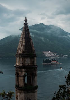 Captivating aerial view of Kotor Bay with historic tower and island in Montenegro.