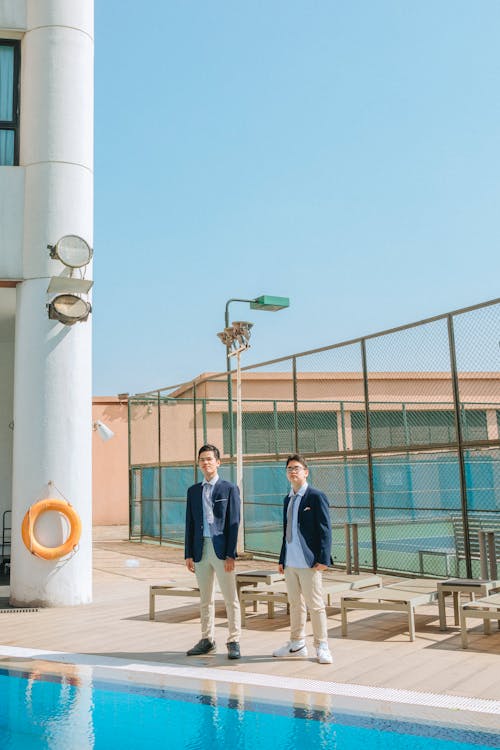 Man in Blue Coat Standing near Swimming Pool