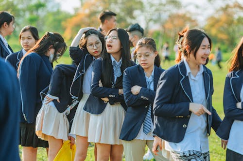 Free Group of Schoolgirls Wearing Uniforms in Park Stock Photo