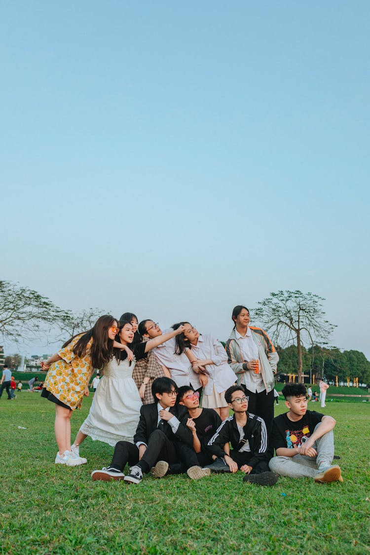 Posing Teenagers Boys And Girls On The Grass