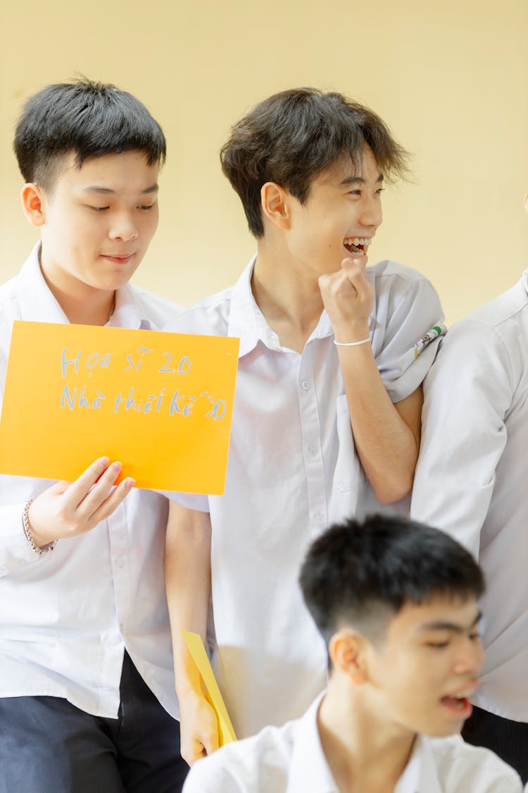 School Boys Holding Yellow Paper Sign